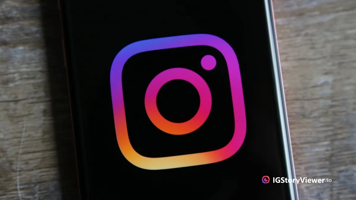 The Instagram logo glowing on a phone screen resting on a wooden desk
