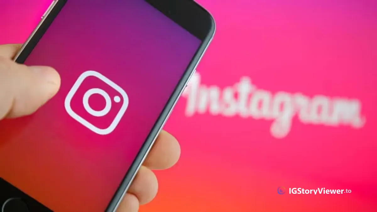 A hand holding a phone displaying the Instagram logo, with the Instagram wordmark blurred in the background