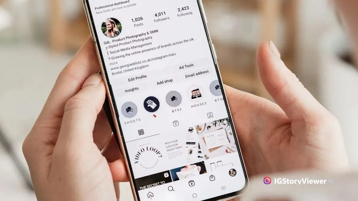 A hand holding a phone showing an Instagram profile with a row of custom-labeled Highlight covers under the bio