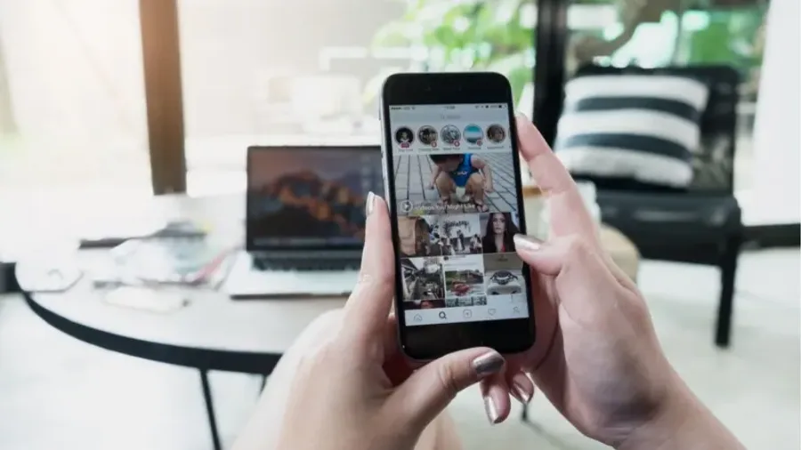 Person browsing Instagram stories on a phone at home